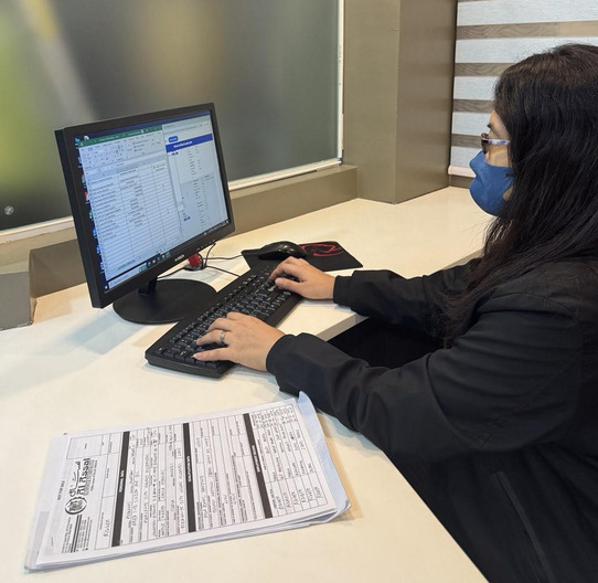 Recruitment professional performing data entry on a desktop computer, representing the efficient and accurate processing of candidate information